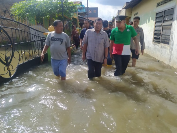 TINJAU : Bupati Deli Serdang, H Ashari Tambunan saat meninjau langsung lokasi banjir di Desa Patumbak Kampung Kecamatan Patumbak.