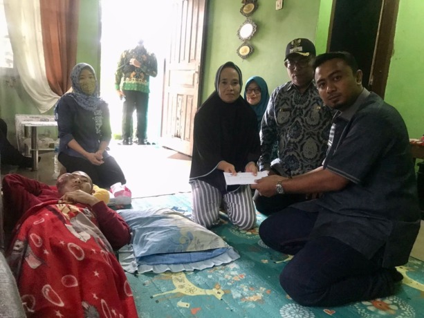 BANTUAN: Wakil Ketua Bidang Pemenangan Pemilu Partai Golkar Dapil XII Binjai/Langkat H. Rizky Yunanda Sitepu (kakan) memberikan bantuan Rp7,5 Juta kepada Toni Penderita Tumor di wajah kanan.