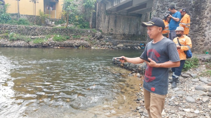 LUBUK LARANGAN: Sahalatua Waruwu (pakai topi), Sekretaris Desa Garoga, menunjukkan lokasi Lubuk Larangan Sungai Garoga, persisnya di bawah jembatan jalan lintas Batangtoru, Tapanuli Selatan, belum lama ini. Dame Ambarita/Metro Tabagsel.