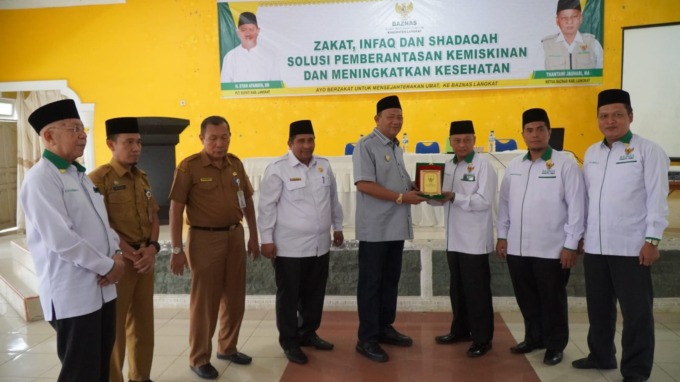 PLAKAT: Plt Bupati Langkat H Syah Afandin SH saat memberikan plakat pada kegiatan sosialisasi Baznas Kabupaten Langkat dengan ASN se-Langkat, di Aula Akper Pemkab Langkat, Stabat, Selasa (10/1).