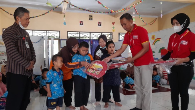 BANTUAN:   Perwakilan Alfamart dan SGM Eksplor memberikan bantuan paket perlengkapan sekolah kepada anak-anak PAUD.