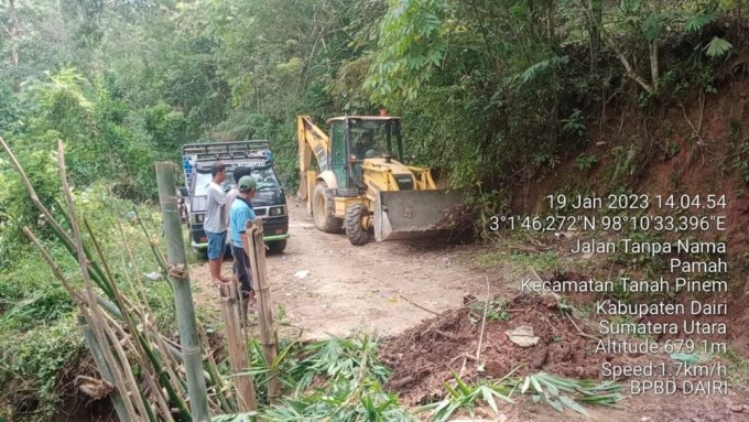 PERBAIKI: Alat berat milik BPBD Kabupaten Dairi sedang melakukan penimbunan tanah terhadap badan jalan yang longsor di Desa Kempawa, Kecamatan Tanah Pinem, Kamis (19/1).