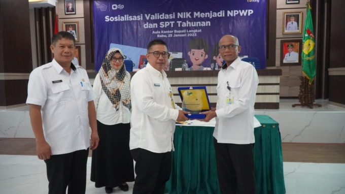 CENDERAMATA: Kepala Kantor KPP Pratama Binjai, Amir Fauzi menerima cenderamata dari Asisten Administrasi Umum, Musti pada kegiatan sosialisasi implementasi NIK menjadi NPWP.