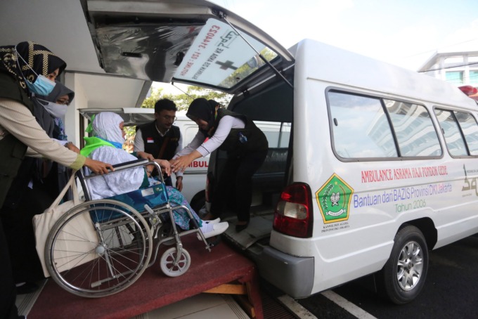 Petugas membantu Calon Jemaah Haji kelompok terbang (kloter) 1 embarkasi haji Jakarta-Pondok Gede masuk kedalam mobil di Asrama Haji Pondok Gede, Jakarta, Jumat (3/6/2022). Sebanyak 389 jamaah calon asal DKI Jakarta yang tergabung dalam kloter 1 embarkasi