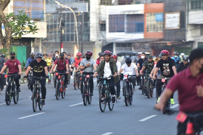 BERSEPEDA:  Presiden Joko Widodo bersama Gubsu Edy Rahmayadi, Kapolda Irjen Pol Panca Putra Simanjuntak, Wali Kota Medan Bobby Nasution dan lainnya bersepeda menyusuri jalan di Kota Medan, Minggu (12/2).