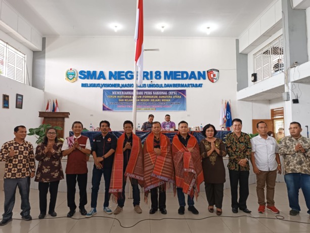 DIULOSI: Perwakilan Forwakum, Kejari Medan dan Kacabdis Medan Selatan di ulosi oleh pihak SMAN 8 Medan, dalam acara penyuluhan hukum, Jumat (3/2).