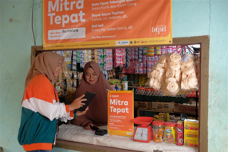JELASKAN: Karyawan BTPN Syariah saat menjelaskan tentang Mobile Banking kepada pelanggan.