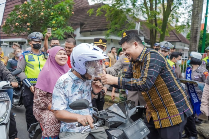 BAGIKAN HELM: Wali Kota Medan Bobby Nasution membagikan Leaflet dan Helm di perempatan Jalan Sutomo Simpang Jalan HM Yamin (dekat RSUD Dr Pirngadi Medan), Jumat (17/3/2023)