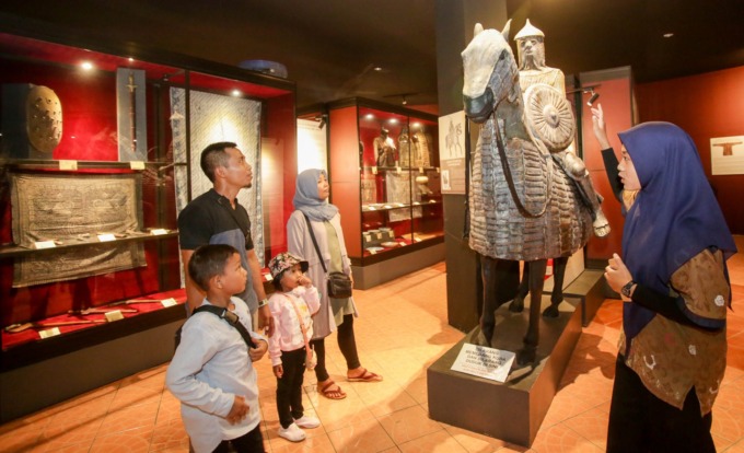 KOLEKSI YANG LENGKAP: Pemandu Museum Indonesian Islamic Art Museum Ika Alfa memberikan penjelasan tentang koleksi kepada pengunjung, Jum