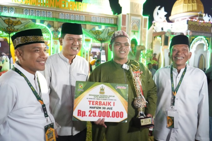 HADIAH: Muhammad Rizqi Mubarok saat menerima hadiah sebagai juara pertama MTQ ke-56.istimewa/sumutpos.