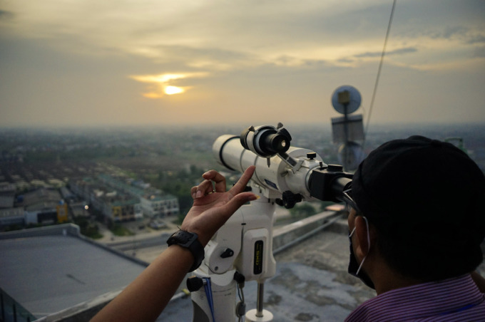 Petugas dari Kemenag Provinsi Riau melakukan pemantauan hilal menggunakan teleskop di puncak gedung The Zuri Pekanbaru untuk menentukan jatuhnya 1 syawal, Pekanbaru, Jumat (22/5/2020) petang. ft: MHD AKHWAN/RIAUPOS
