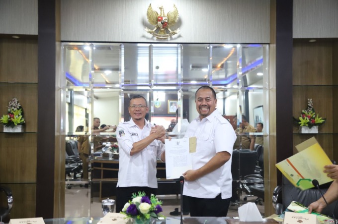 TERIMA: Kadispora Binjai, Iwan Setiawan (kiri) menerima surat keputusan Gubernur Sumut terkait Kota Binjai menjadi tuan rumah untuk cabor gulat dalam ajang PON tahun 2024 dari Kadispora Sumut (kanan).Istimewa/Sumut Pos.