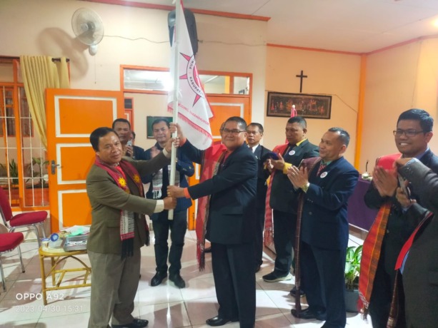 SERAHKAN. Ketua DPW Raja Sitempang Sumut, Peran Simanihuruk SE, MSi menyerahkan bendera pataka kepada Ketua DPC Punguan Raja Sitempang Kabupaten Dairi, Ramses Sitanggang SPd, MM saat pelantikan di Gedung Sada Ahmo, Minggu (30/4).RUDY SITANGGANG/SUMUT POS
