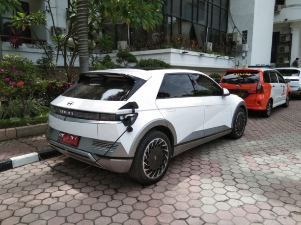 MOBIL LISTRIK: Satu Unit Mobil listrik berwarna putih yang merupakan mobil dinas Wakil Wali Kota Medan, H. Aulia Rachman sedang diparkirkan di halaman depan kantor Wali Kota Medan, Jumat (19/5/2023) siang. Tampak mobil tersebut sedang diisi daya listrik.