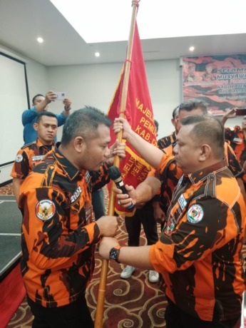 TERIMA: Junaidi menerima bendera pataka MPC PP Kabupaten Deliserdang.