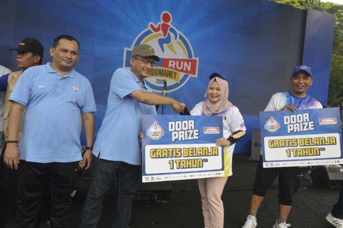 SERAHKAN : Senior Manager Marketing Indomaret Head Office, Muhammad Agus Novianto serahkan hadiah voucher belanja gratis setahun.