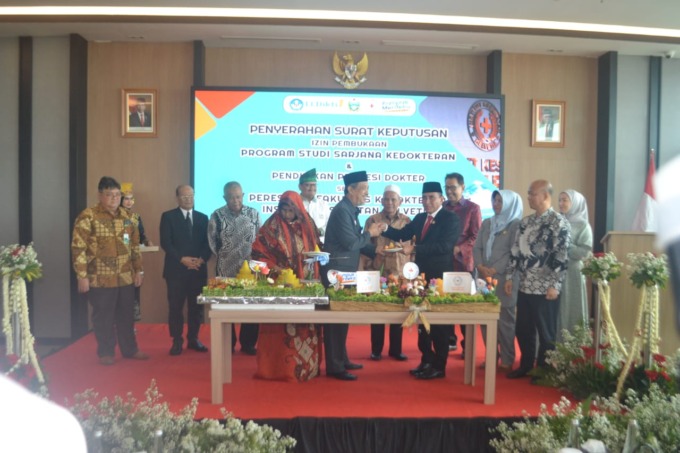 TUMPENG: Gubsu H Edy Rahmayadi menyerahkan nasi tumpeng pada Rektor Institut Kesehatan Helvetia Dr H Ismail Efendy MSi saat peresmian fakultas kedokteran.DEDDI MULIA PURBA/SUMUT POS.