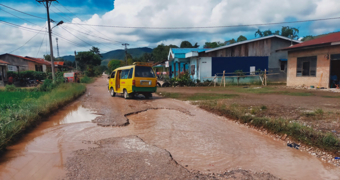 RUSAK PARAH: Mobil penumpang umum pedesaan saat melintasi satu titik badan jalan rusak yang menghubungkan Kota Sidikalang, Kecamatan Sidikalang, dengan Kota Parongil, Kecamatan Silima Pungga-Pungga, Kabupaten Dairi. Rudy Sitanggang/Sumut Pos.