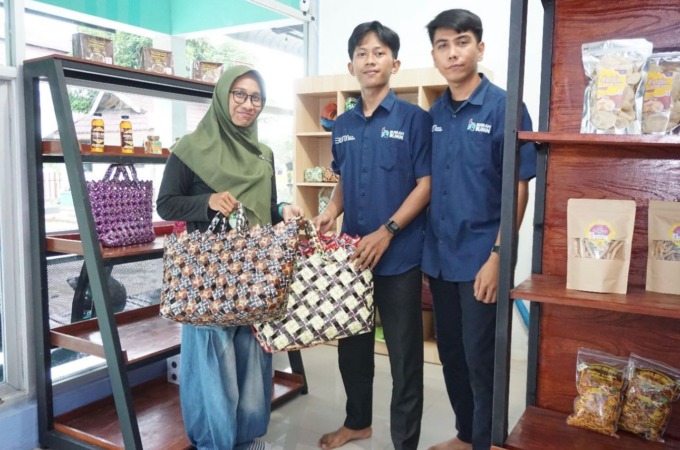 Salah satu masyarakat kota sibolga (kiri) membeli tas tangan yang terbuat dari sampah plastik bersama petugas rumah BUMN Sibolga (kemeja biru dongker)