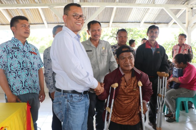 BANTUAN: Bupati Toba Poltak Sitorus menyerahkan bantuan tongkat kepada penyandang disabilitas.