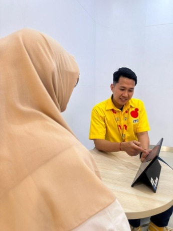 LAYANI: Karyawan IM3 saat melayani karyawan di Gerai IM3 Pekan Baru yang memiliki wajah baru.