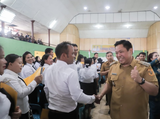 SELAMAT: Bupati Dairi, Eddy KA Berutu didampingi Kepala BKPSDM, Junihardi Siregar mengucapkan selamat kepada ratusan tenaga guru honorer yang diangkat dan menerima SK PPPK di GOR Sidikalang, Senin (31/7/2023)