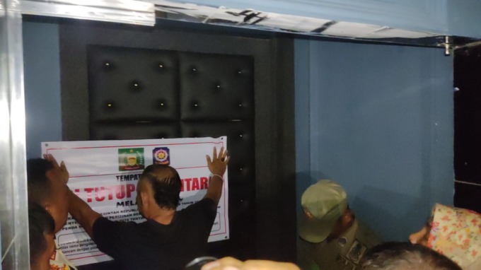 DAMPINGI: Bambang Sembiring selaku Humas Diskotek OKG saat mendampingi tim terpadu dan membantu pasang spanduk penyegelan.Teddy Akbari/Sumut Pos.