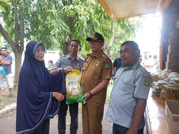 MURAH: Dirut PUD Pasar Medan, Bobby Nasution menyerahkan beras kepada pembeli mobil keliling pasar murah.