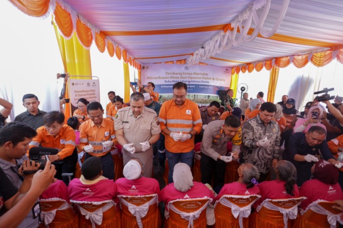 Direktur & CFO PT Agincourt Resources Noviandri Hakim (tengah berbaju oranye) bersiap meneteskan obat ke mata pasien katarak bersama dengan Kapolres Tapanuli Selatan AKBP Imam Zamroni di RS Bhayangkara Batangtoru, Tapanuli Selatan, Kamis (14/9/2023). (Dok