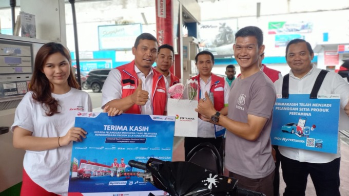 Executive GM Pertamina Sumbagut, Freddy Anwar saat memberikan pelanggan hadiah berupa handphone dan bingkisan.(BAGUS SYAHPUTRA/SUMUT POS)