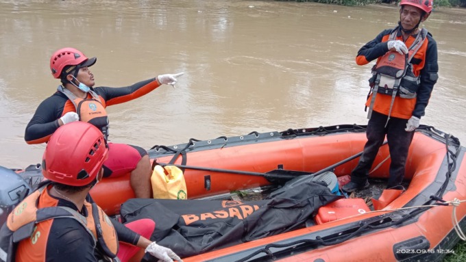 EVAKUASI: Petugas BPBD mengevaluasi jasad korban dari jembatan Sungai, usai tergelincir di bantaran Sungai Deli.