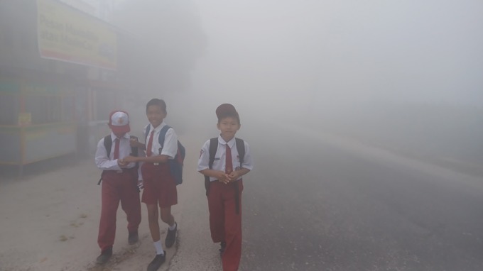 ASAP TEBAL:   Murid sekolah dasar tidak mengenakan masker di tengah asap tebal yang pekat menyelimuti Kota Sampit, Senin (2/10). Kasus kebakaran hutan dan lahan (karhutla) tengah melanda di sejumlah wilayah Indonesia saat ini.