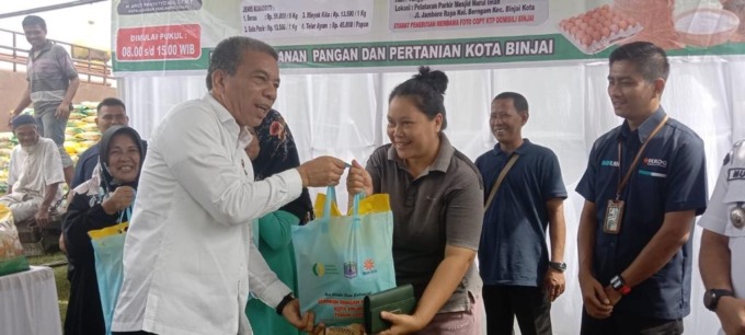 SERAHKAN: Sekdako Binjai Irwansyah Nasution, saat menyerahkan secara simbolis beras Bulog kepada masyarakat pada Gerakan Pangan Murah yang digelar Pemko Binjai di Kelurahan Berngam, Kecamatan Binjai Kota, belum lama ini.