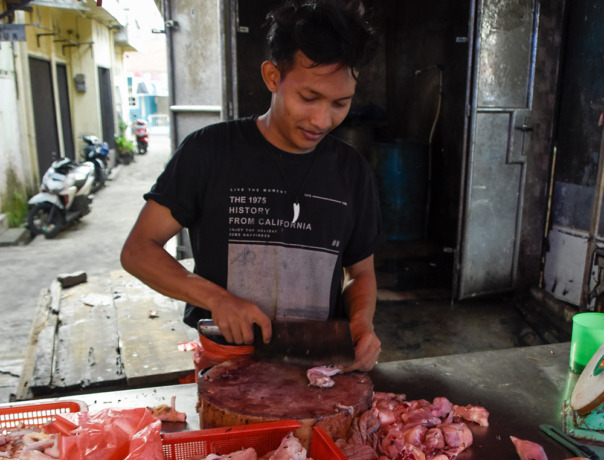 POTONG: Pedagang saat memotong daging ayam.