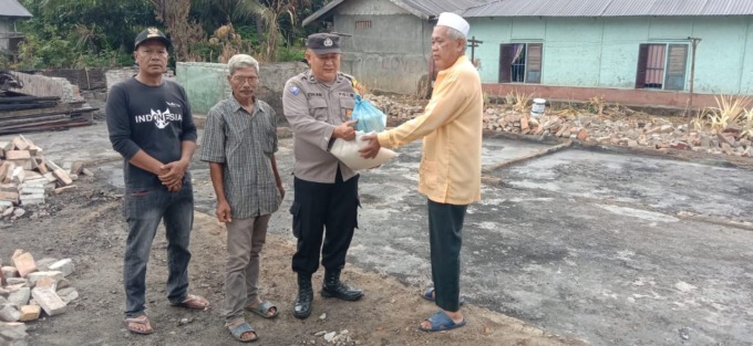 BANTUAN: Bhabinkamtibmas Desa Huta Durian Aipda Deni Setiawan menyerahkan bantuan kepada Yusuf korban kebakaran, Jumat ( 17/11/2023 ).