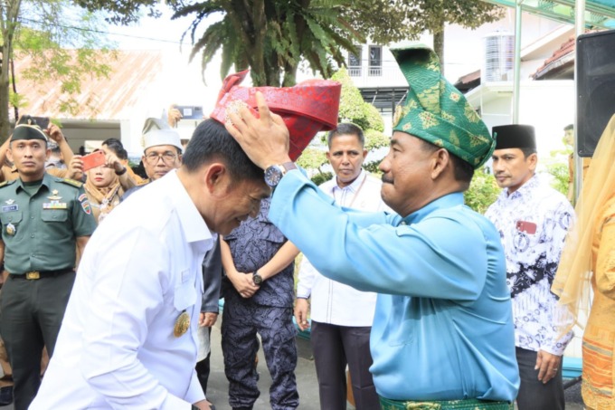TANJAK: Wali Kota Binjai, Amir Hamzah memasang tanjak kepada Pj Gubsu, Hasanuddin.Istimewa/Sumut Pos.