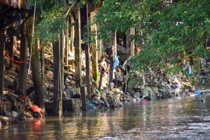 Seorang warga sedang beraktivitas di pinggir Sungai Deli Medan, Senin (11/9/2023).