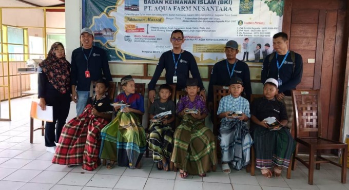 SANTUNAN: Hendra Syahputra HR Manager Regal Springs Indonesia memberikan santunan kepada anak karyawan serta warga setempat. (istimewa/sumutpos.co)