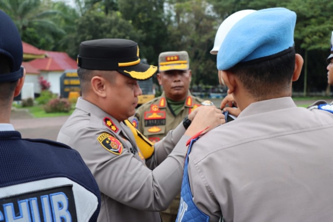 LILIN TOBA: Kapolres Deliserdang saat memasangkan tanda kepada pasukan pengamanan Operasi Lilin Toba 2023.
