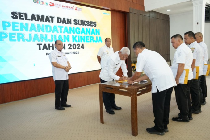 TANDA TANGANI: Bupati Asahan H Surya BSc menandatangangi penjanjian kinerja bersama sejumlah ASN di sela-sela Rakorpem.