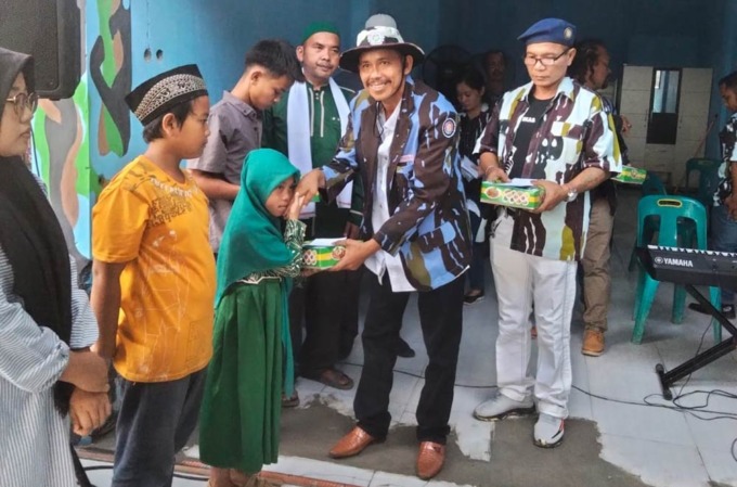 Ketua PAC IPK patumbak Robert pakpahan menyerahkan bantuan anak yatim dan kaum dhuafa.