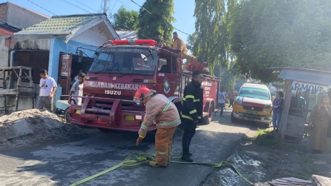 PADAMKAN: Tim regu pemadam kebakaran Dinas Kebakaran dan Penyelamatan Kota Tebingtinggi memadamkan api dengan menurunkan empat mobil Damkar ke lokasi kebakaran.