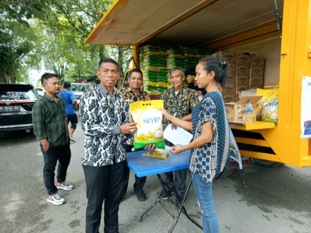 MURAH: Dirut PUD Pasar Medan Suwarno saat melayani warga yang membeli sembako di Pasar Murah Keliling.