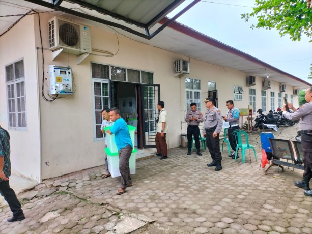 JAGA: Personel Polres Tebingtinggi yang bertugas di Kecamatan Padang Hulu melakukan penjagaan saat rekapitulasi tingkat Kecamatan.
