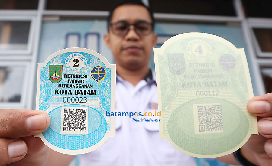 Petugas Dinas Perhubungan (Dishub) Kota Batam menunjukkan stiker parkir berlangganan untuk kendaraan roda dua dan roda empat, Senin (13/5).