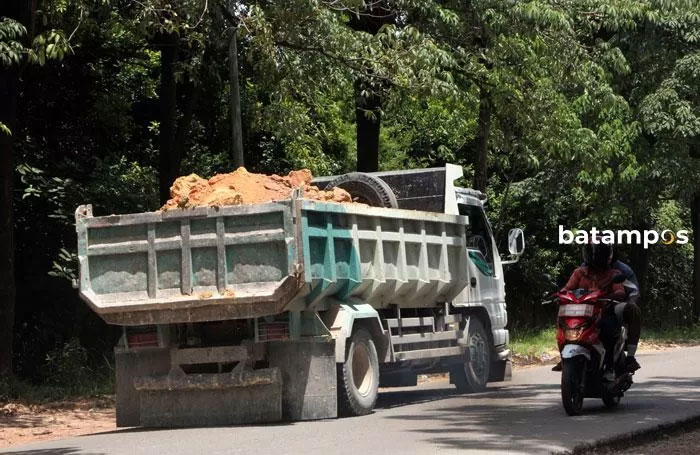 Ilustrasi truk memuat tanah tanpa penutup.