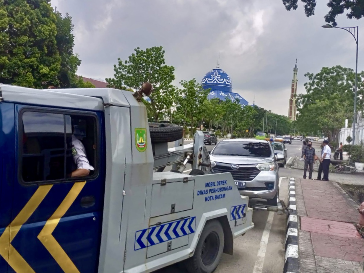 Petugas Dishub Kota Batam menderek kendaraan yang parkir sembarangan di bahu jalan depan kantor Wali Kota Batam.