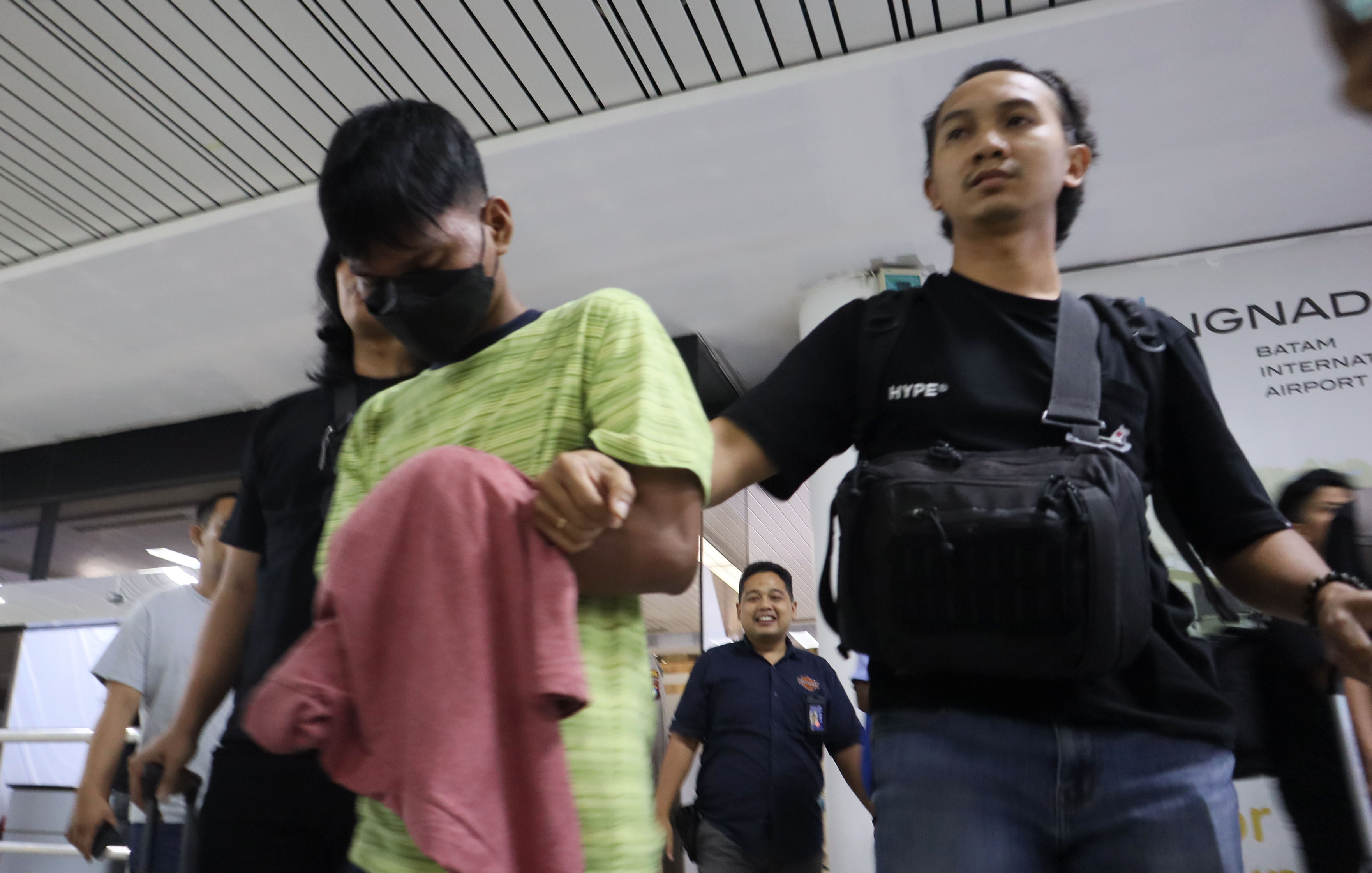 Anggota Polisi membawa pelaku pembunuhan yang  berhasil ditangkap saat tiba di Bandara Hang Nadim Batam, Jumat (12/7).