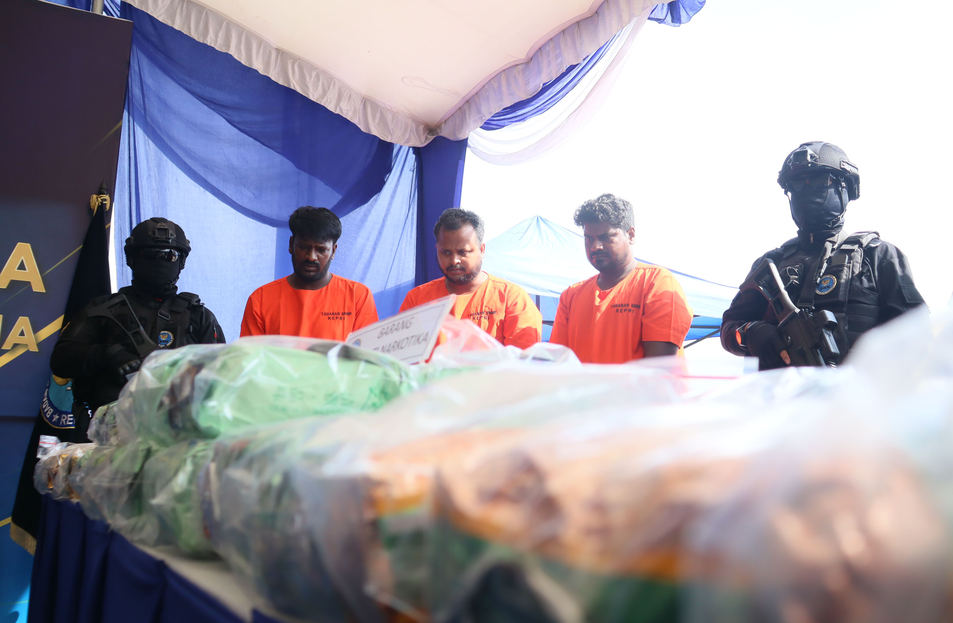 Petugas BNN menjaga  tiga orang yang diamankan  beserta barang bukti narkoba saat akan rilis di Dermaga Bea Cukai di Tanjunguncang, Rau (17/7). BNN RI bersama Bea Cukai mengamankan 106 kilogram narkotika jenis sabu dari kapal Legend Aquarius . F Cecep Mul