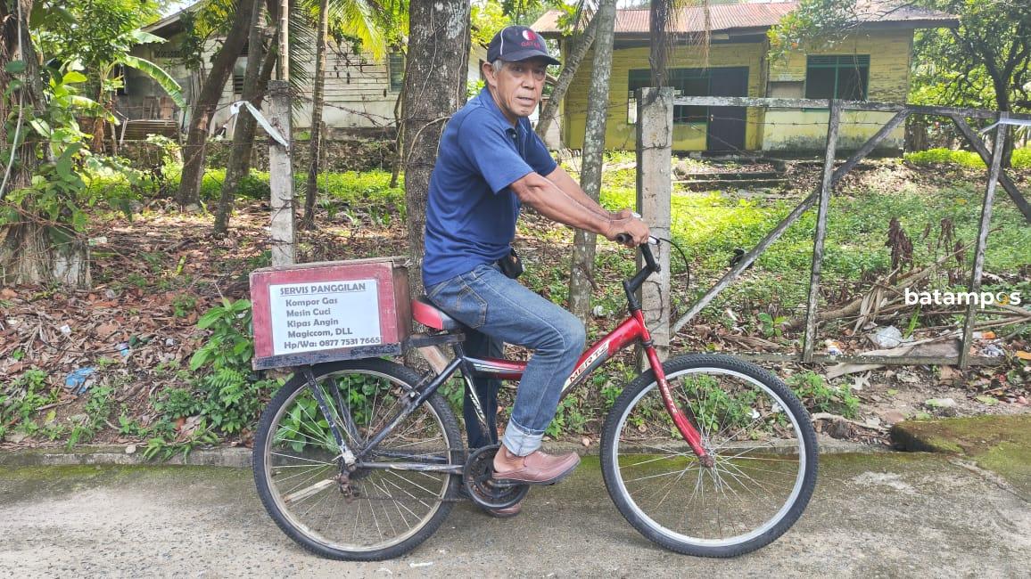 Potret Syafrizal, tukang servis keliling menggunakan sepeda saat melintas di Jalan Sei Jang Tanjungpinang.